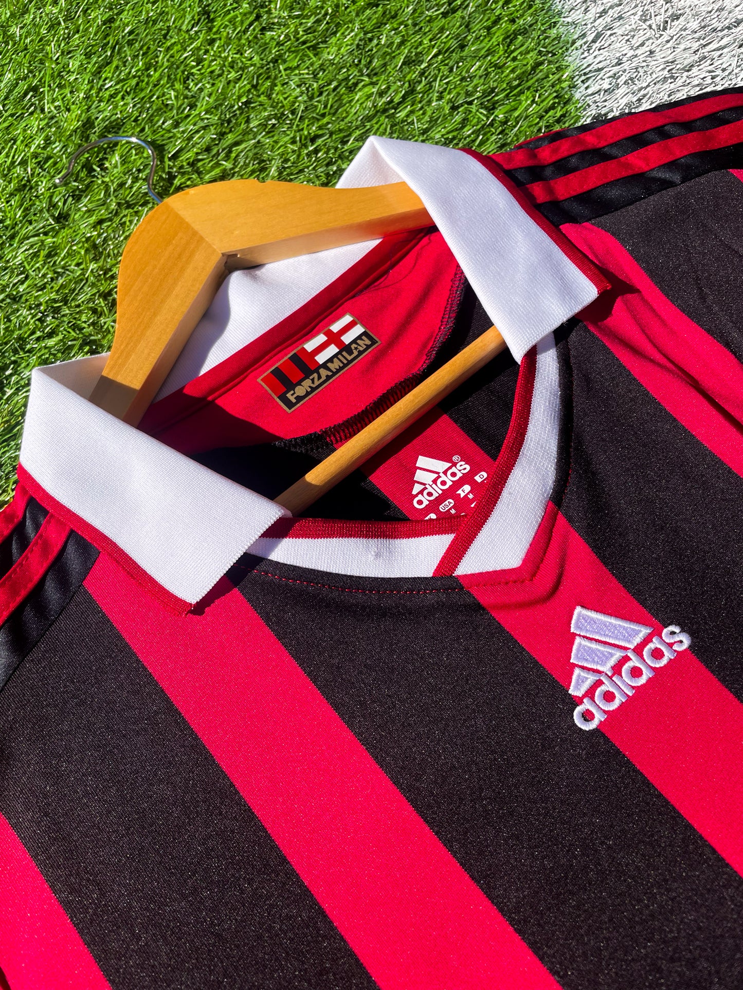 Close-up of Adidas logo and AC Milan crest on the 2009-2010 home jersey