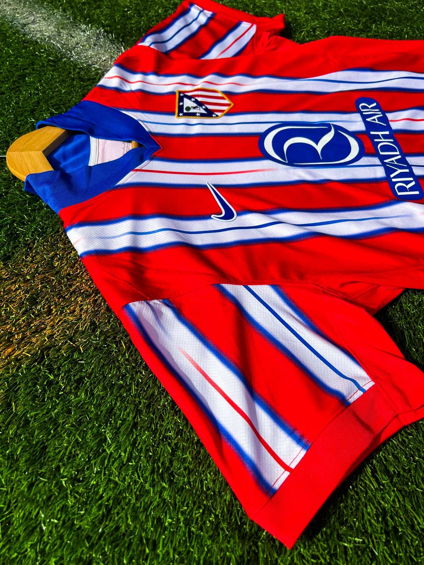 Close-up of Nike logo and Atlético Madrid crest on the 2024-2025 home jersey