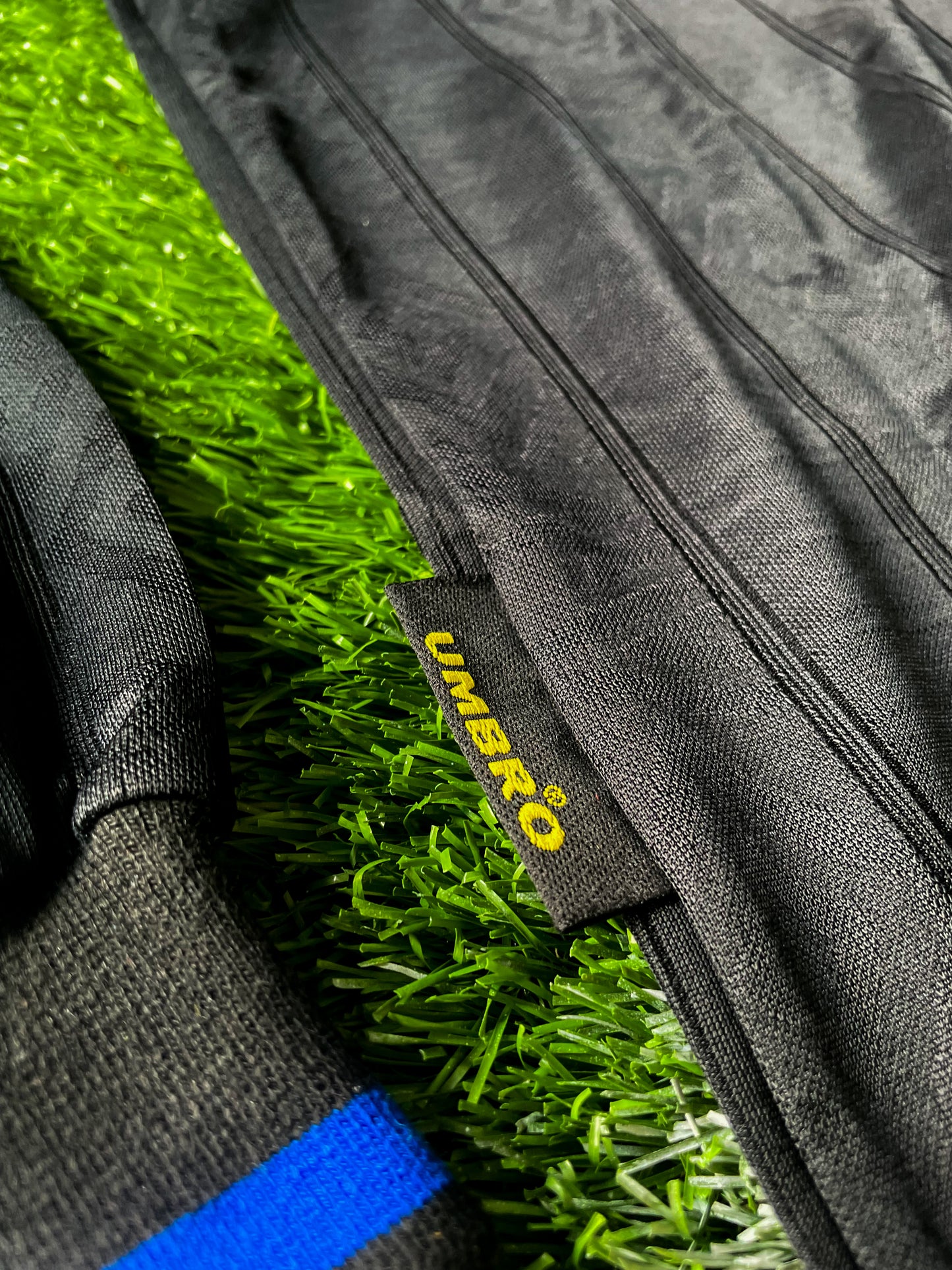 Close-up of Umbro logo, club crest, and fold-over collar