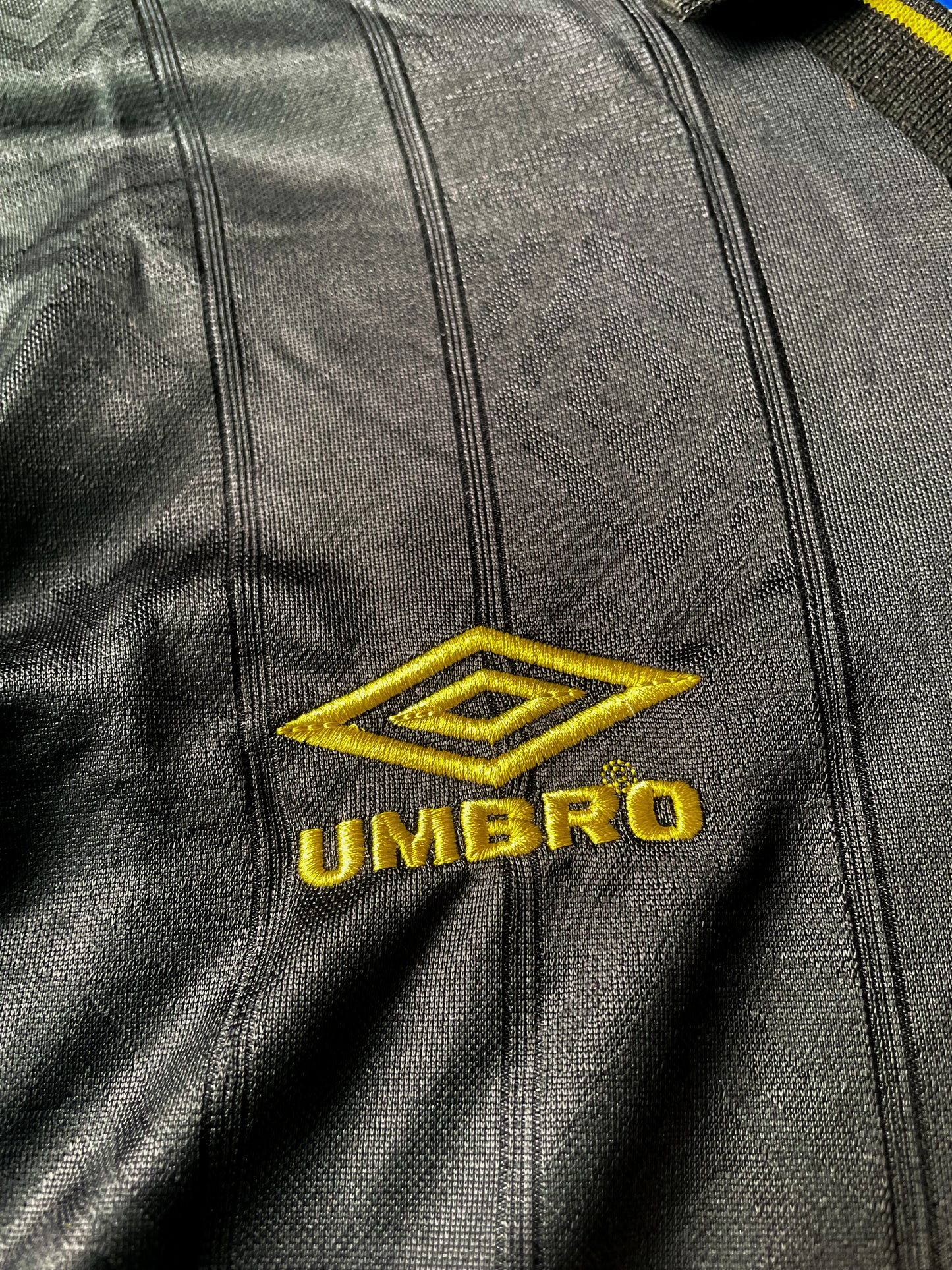 Close-up of Umbro logo, club crest, and fold-over collar