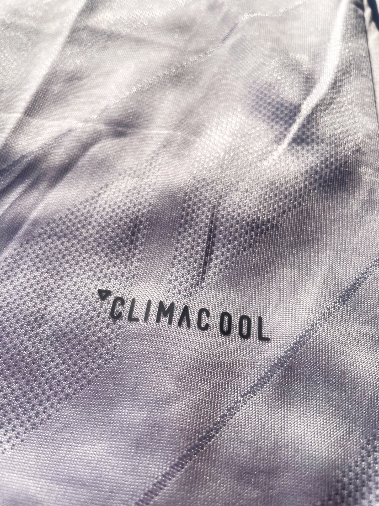 Close-up of embroidered club crest and Nike swoosh on white fabric