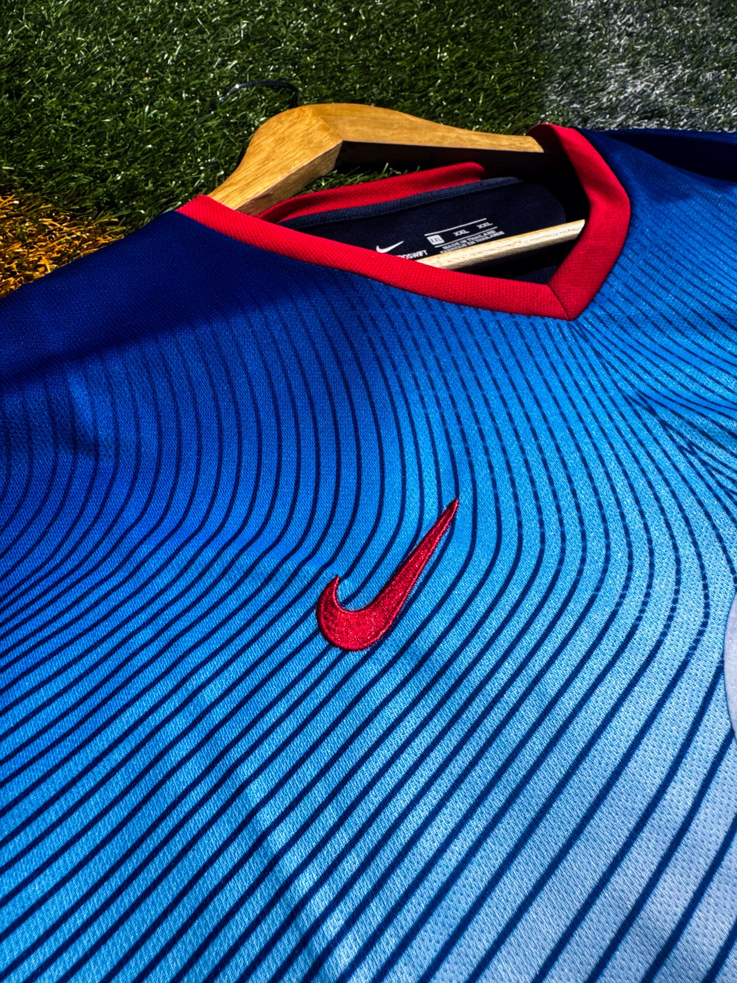 Close-up of crest and yellow detailing on blue Nike design