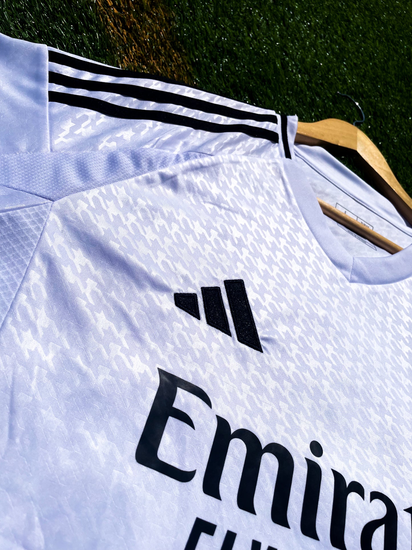 Close-up of embroidered Real Madrid crest and Adidas logo on white fabric