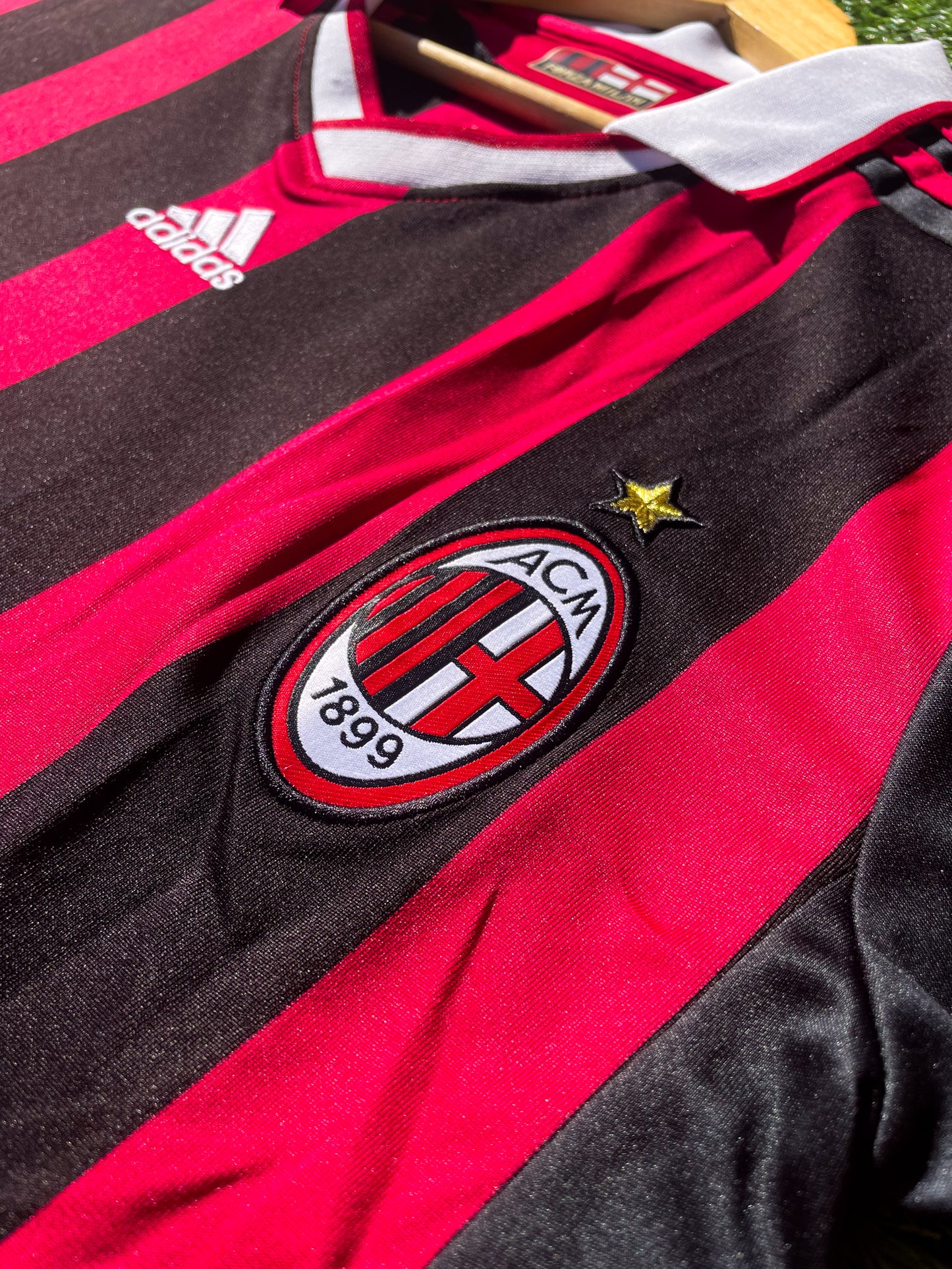 Close-up of Adidas logo and AC Milan crest on the 2009-2010 home jersey