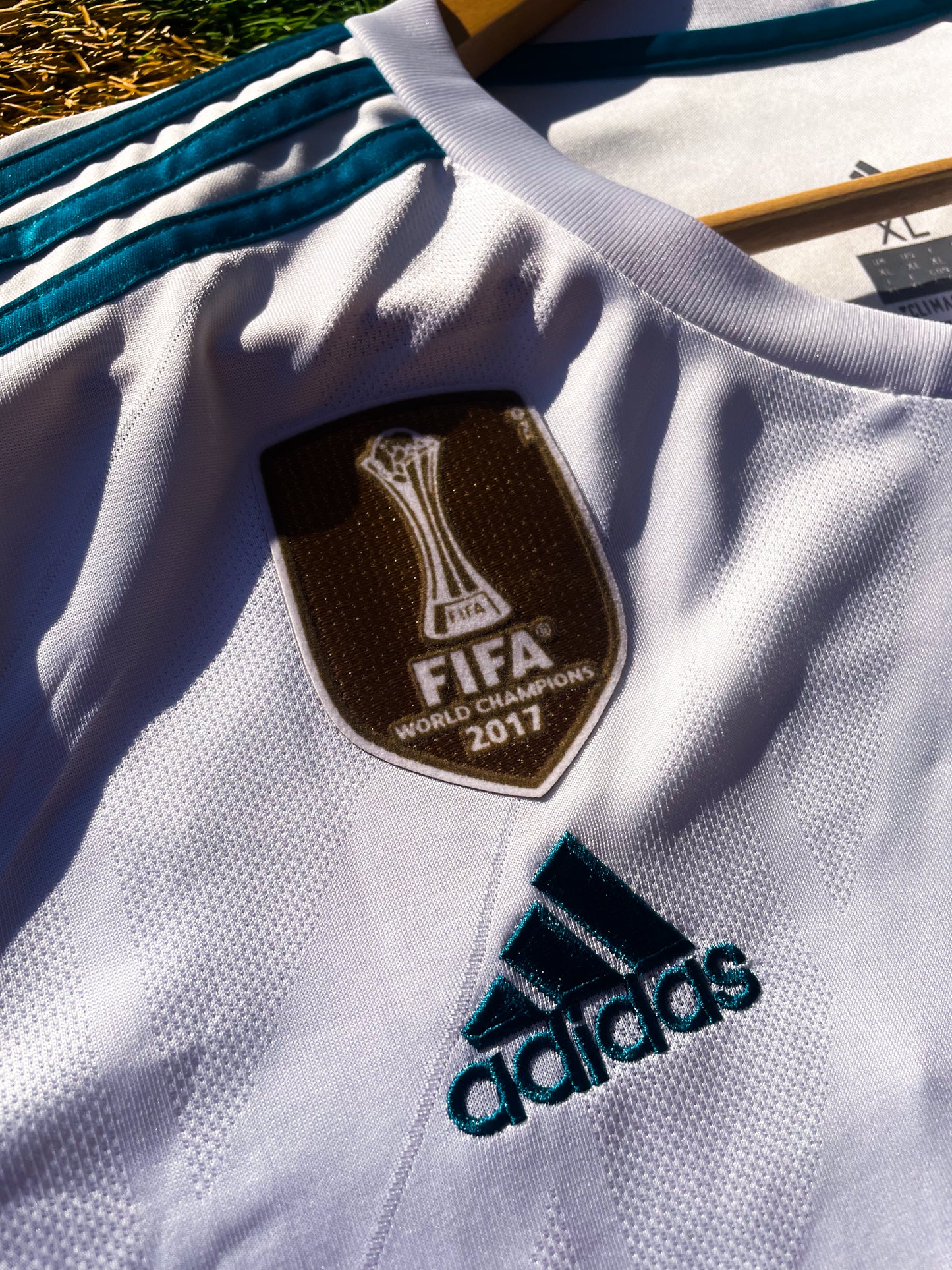 Close-up of embroidered club crest and Nike swoosh on white fabric