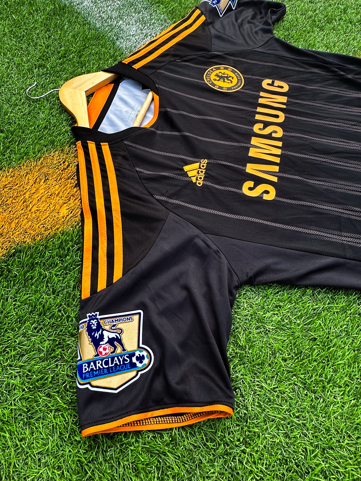 Close-up of Adidas logo, club crest, and orange details