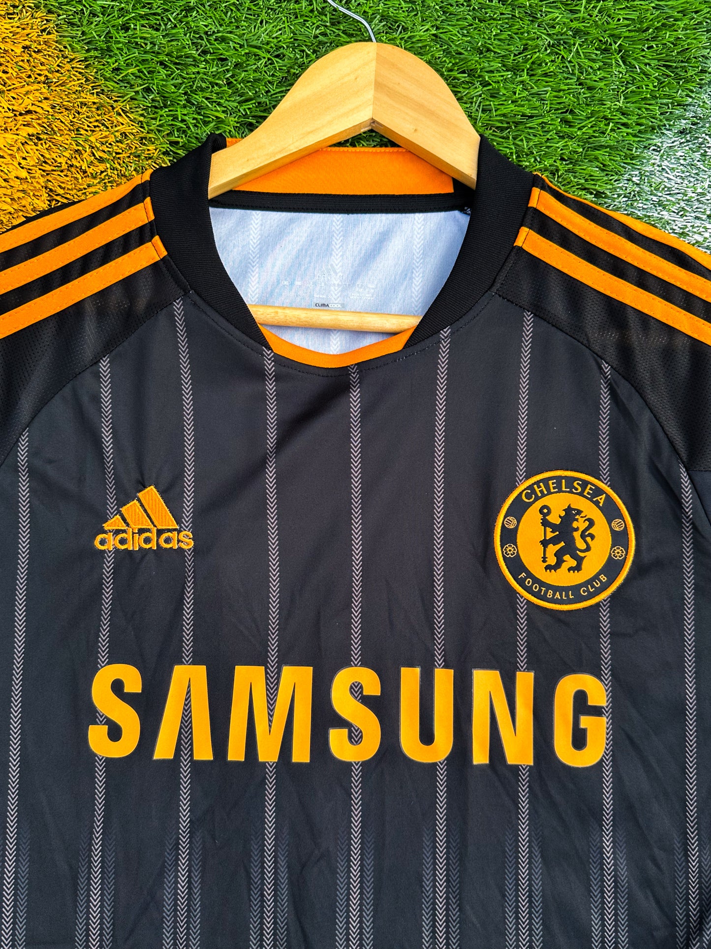 Close-up of Adidas logo, club crest, and orange details