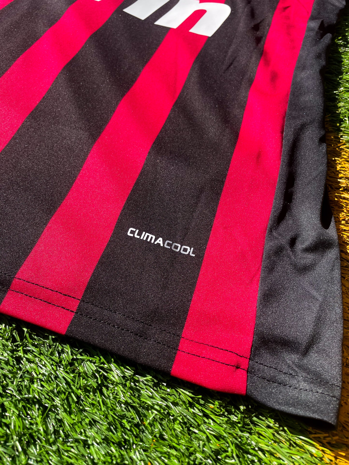 Close-up of Adidas logo and AC Milan crest on the 2009-2010 home jersey