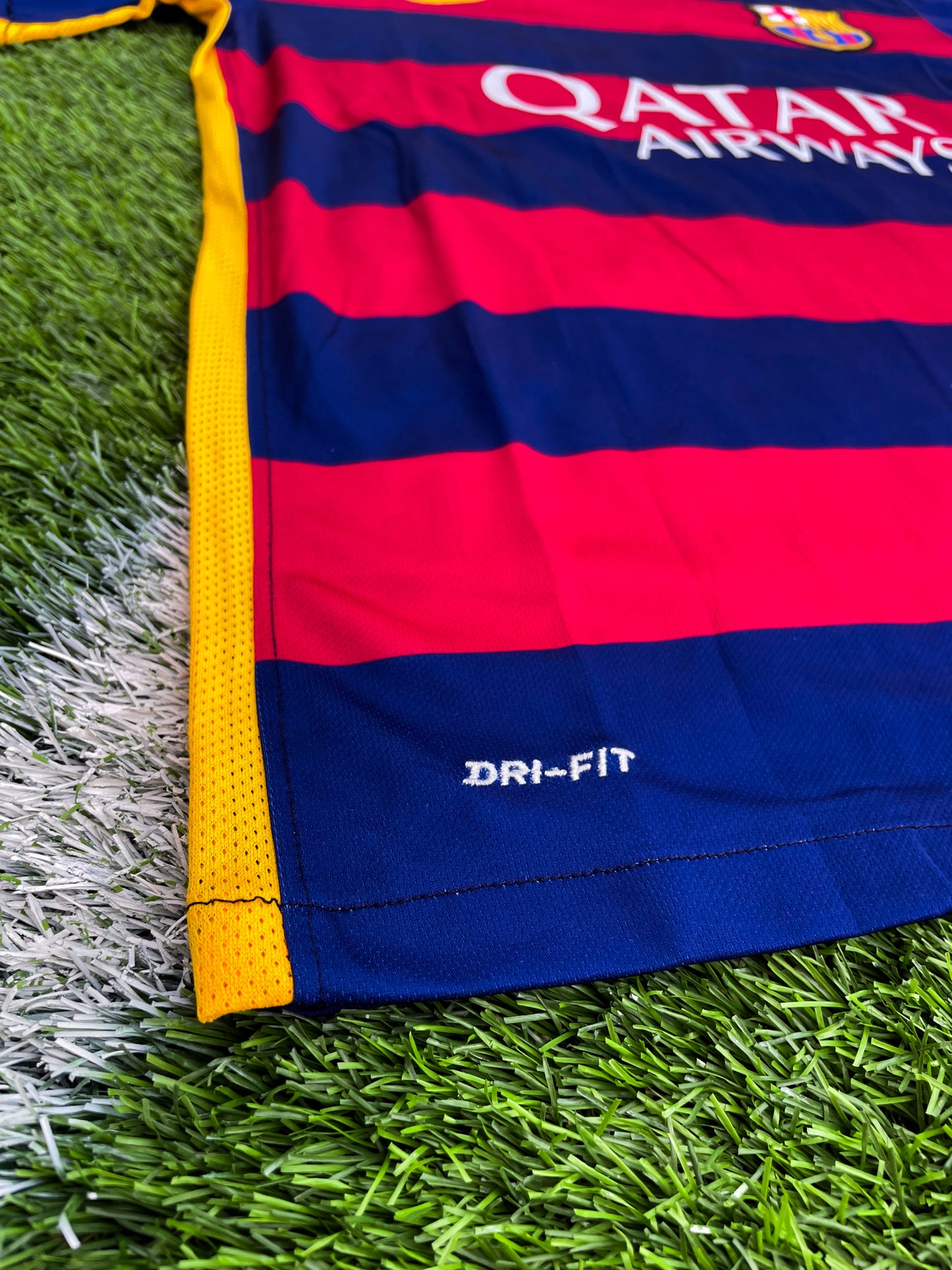 Close-up of Nike logo and Barça crest on red-blue stripes