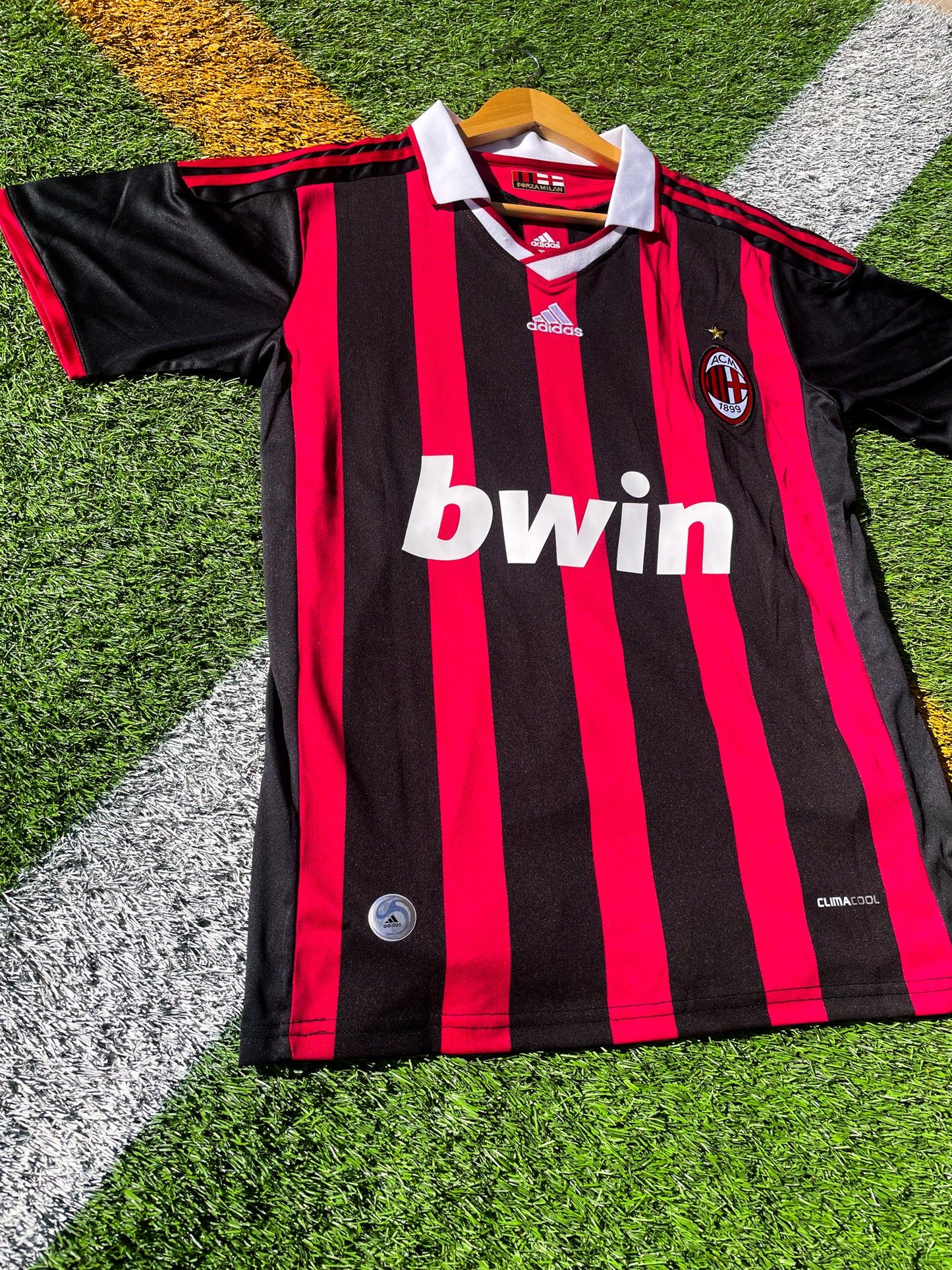 Close-up of Adidas logo and AC Milan crest on the 2009-2010 home jersey