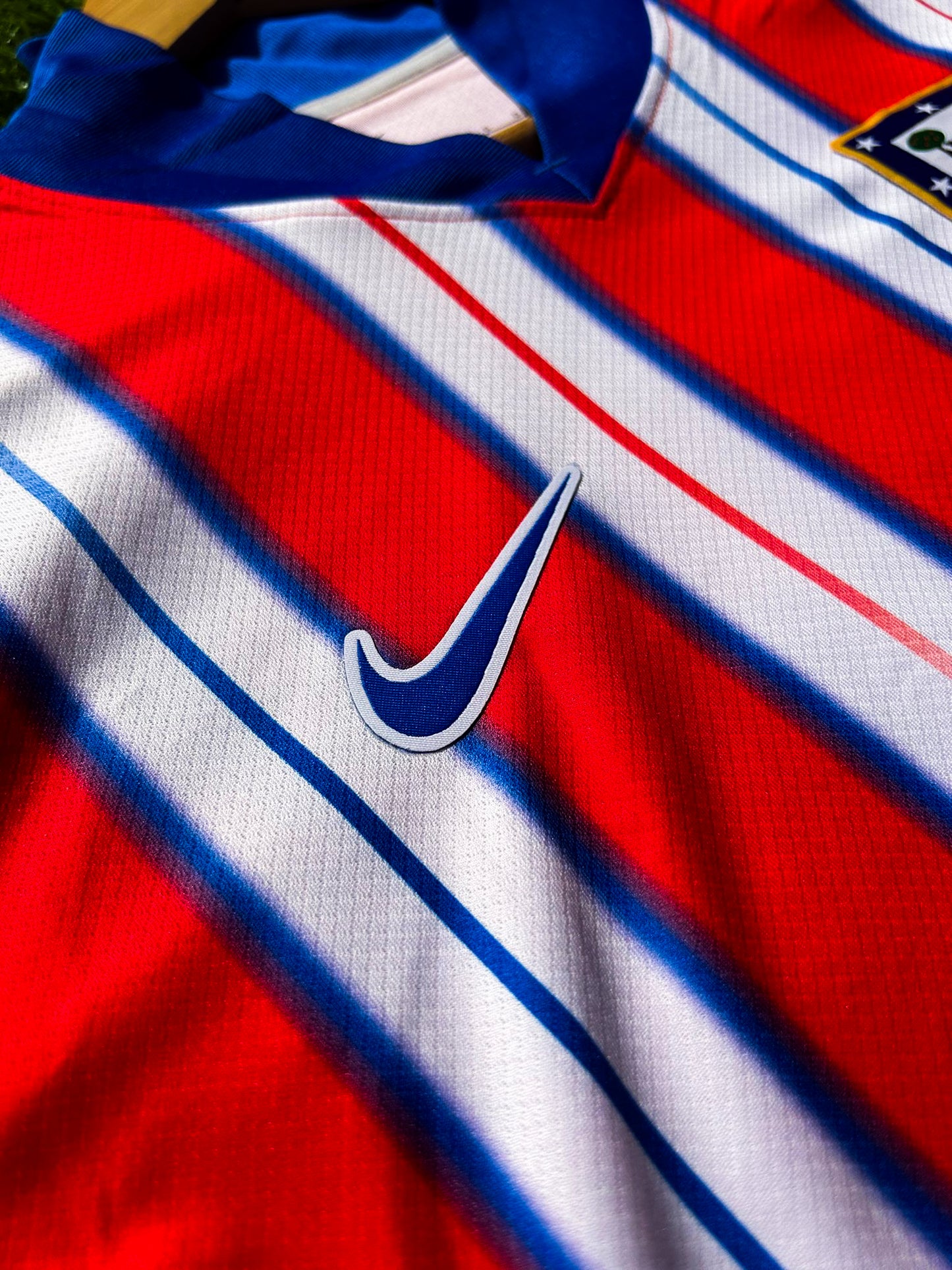 Close-up of Nike logo and Atlético Madrid crest on the 2024-2025 home jersey