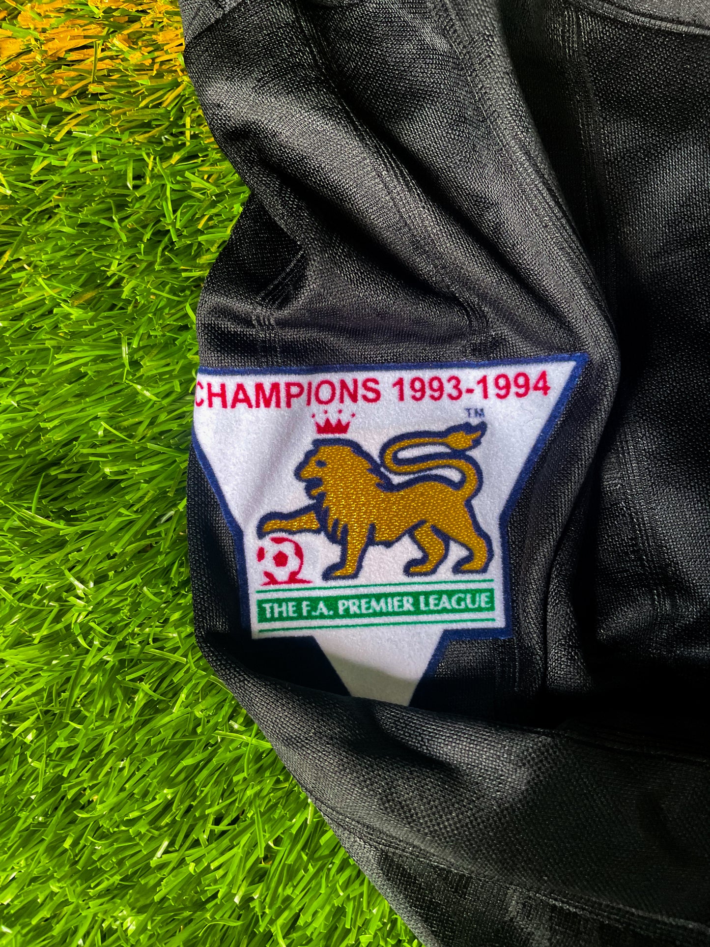 Close-up of Umbro logo, club crest, and fold-over collar