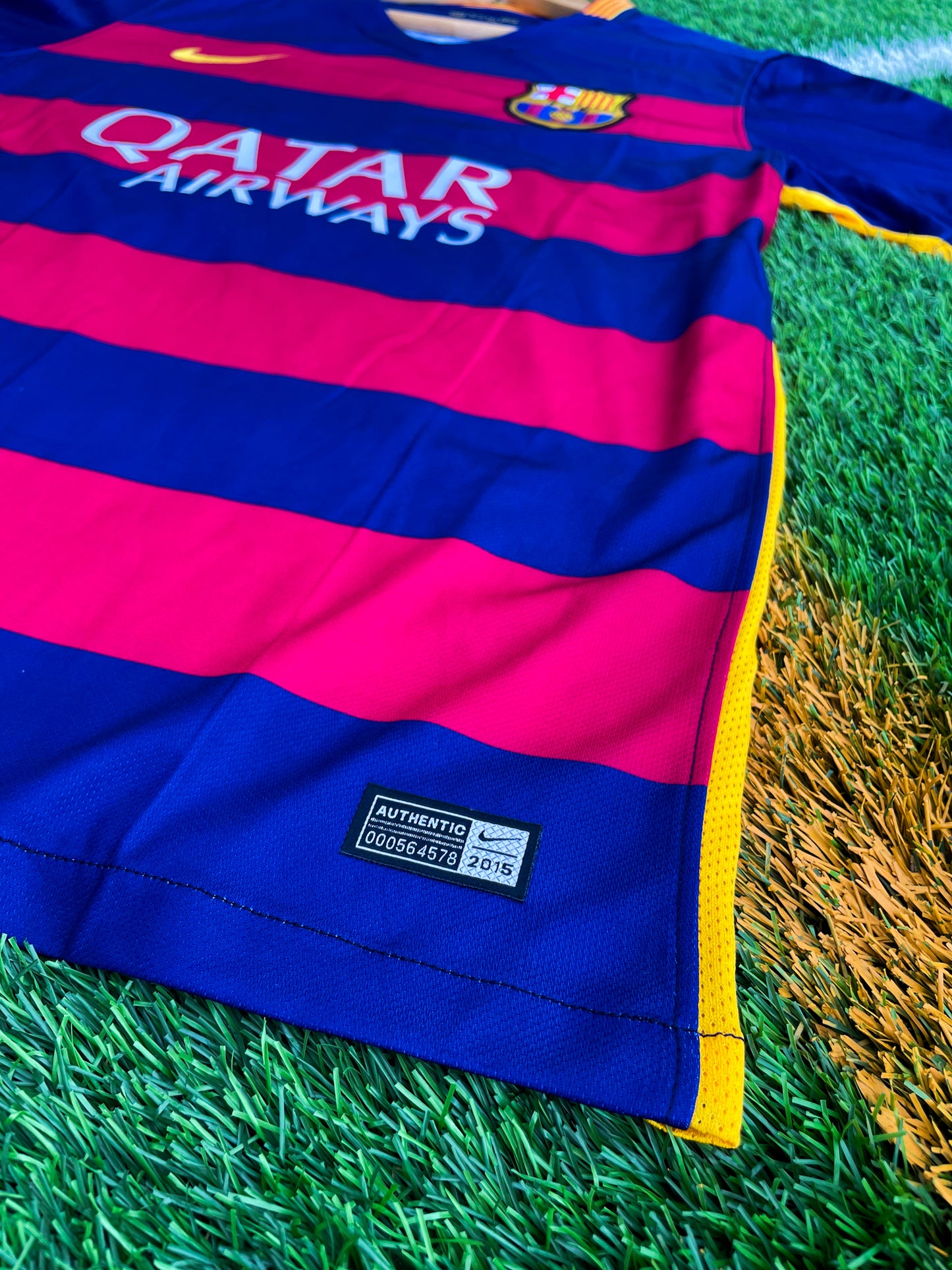 Close-up of Nike logo and Barça crest on red-blue stripes