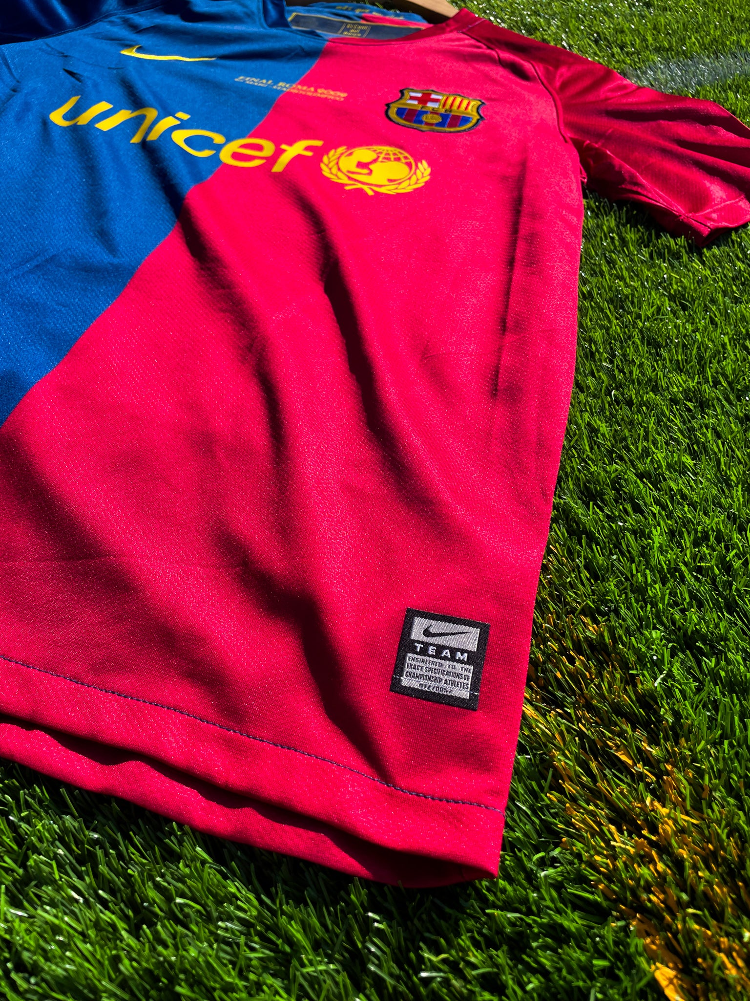 Close-up of Nike logo and club crest on the split-color design

