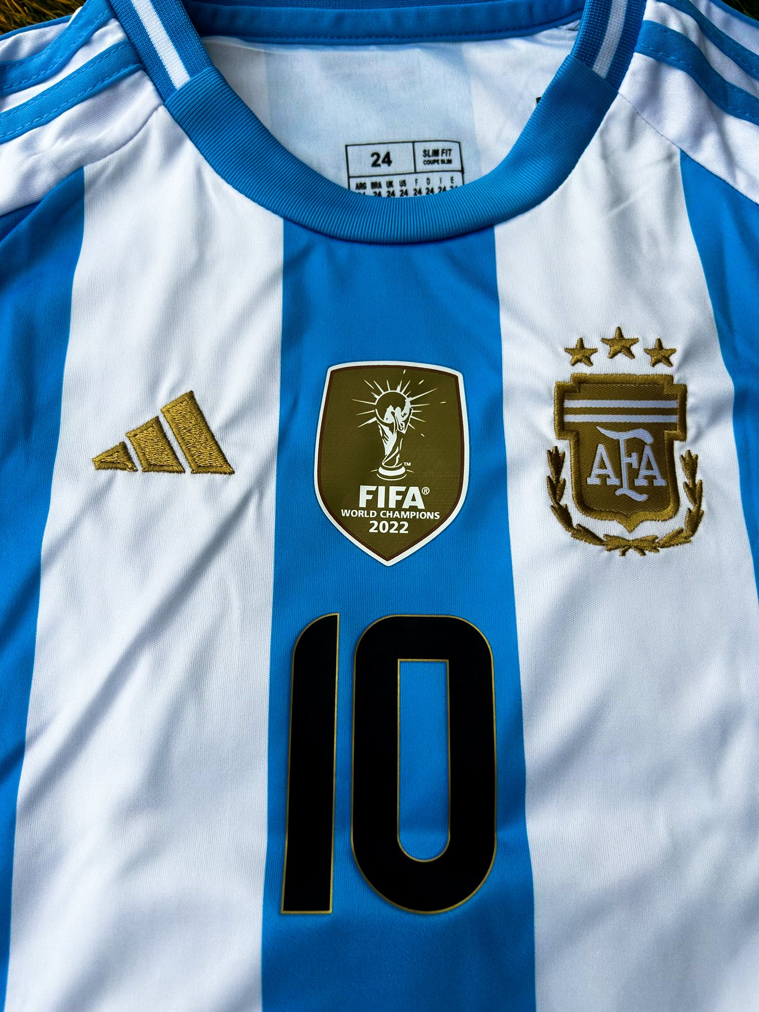 Close-up of Copa América champions badge and Adidas branding on youth jersey.