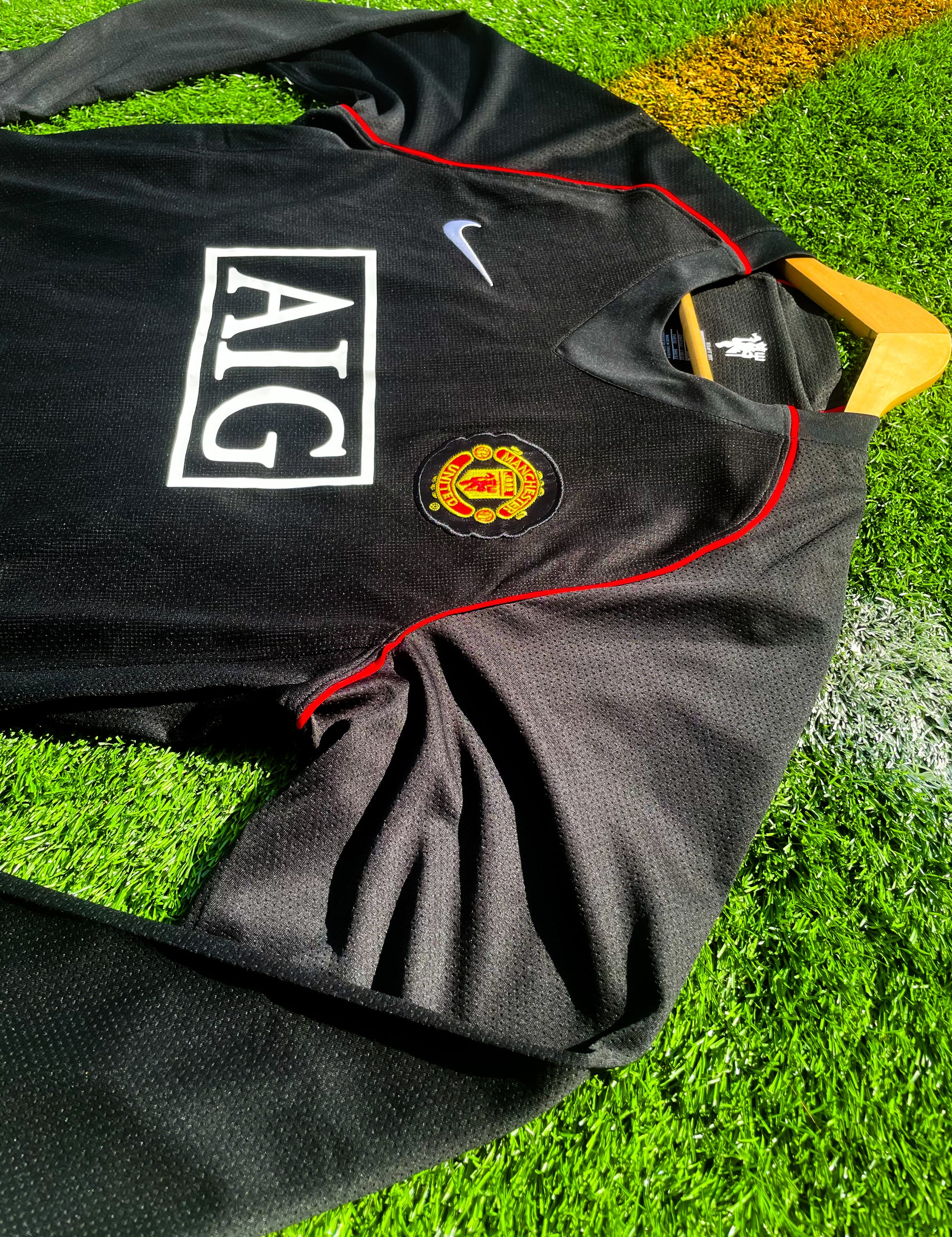 Close-up of gold Nike logo and club crest


