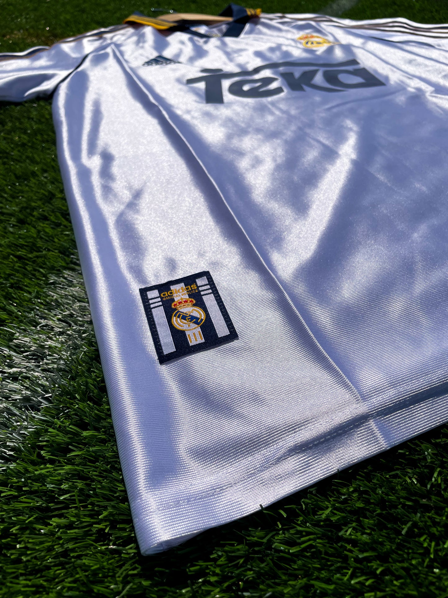 Close-up of embroidered Real Madrid crest and Adidas logo

