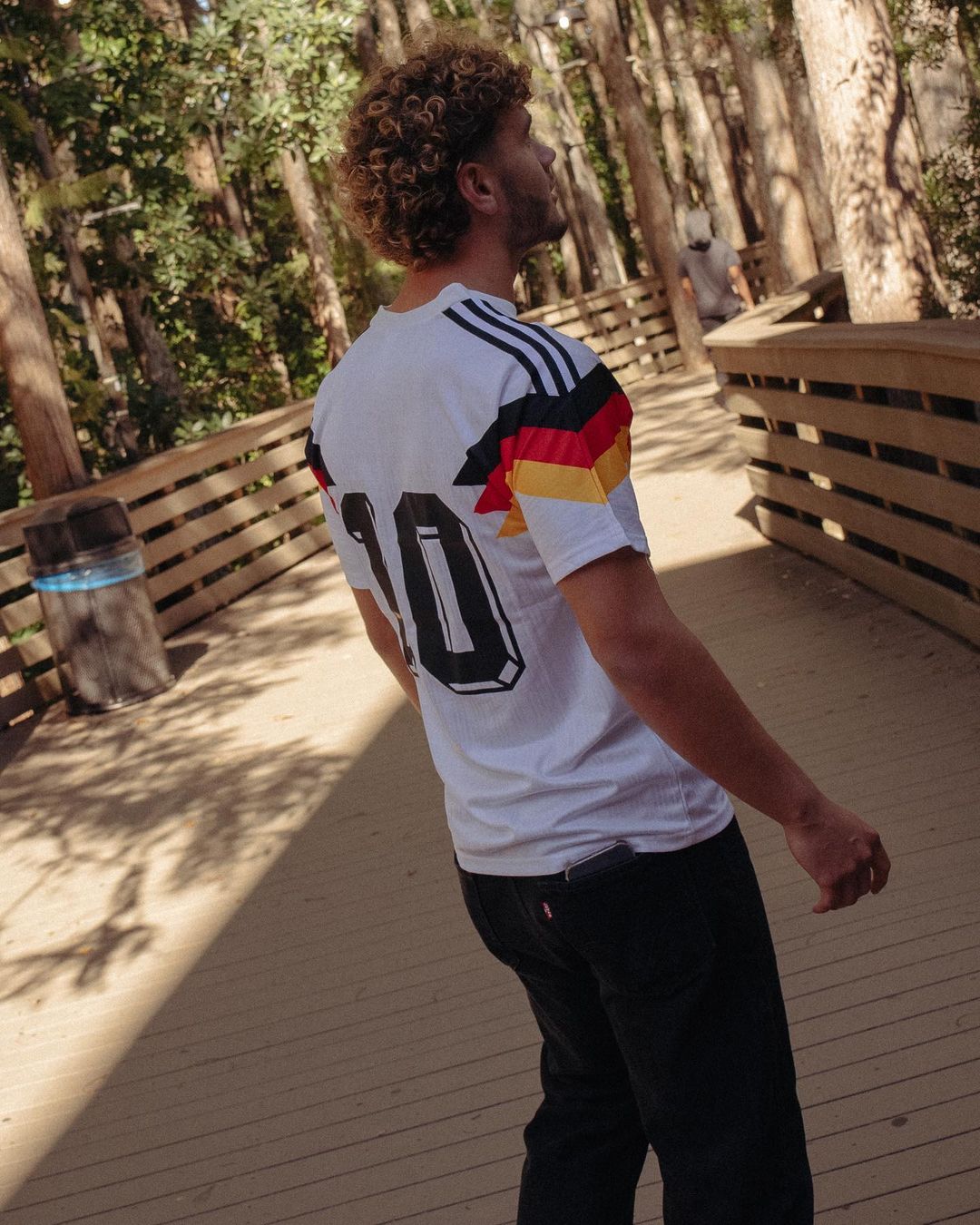 Model wearing the Germany 1990 home jersey styled with streetwear for a retro football look

