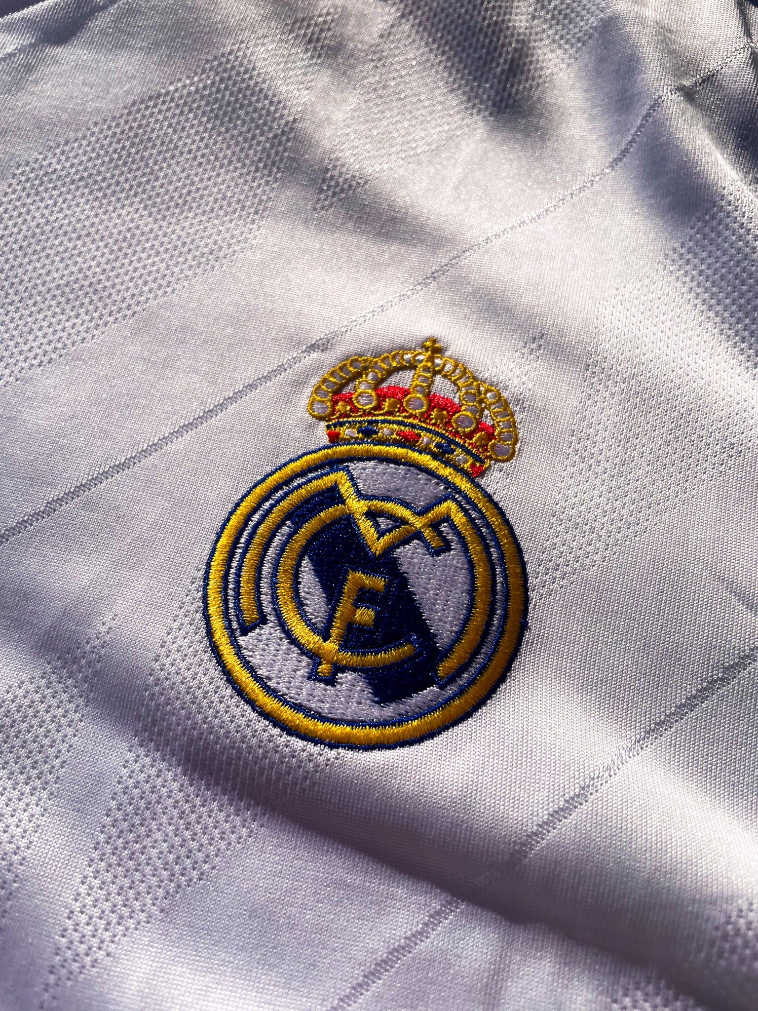 Close-up of embroidered club crest and Nike swoosh on white fabric

