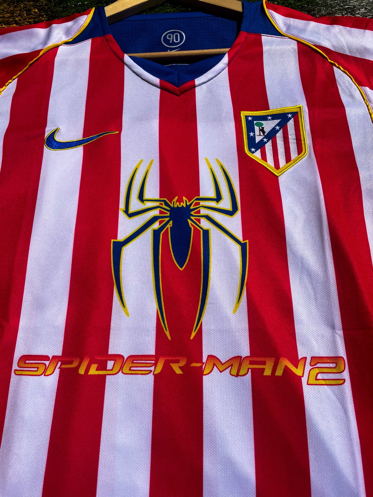 Close-up of Spiderman sponsor logo and embroidered club crest

