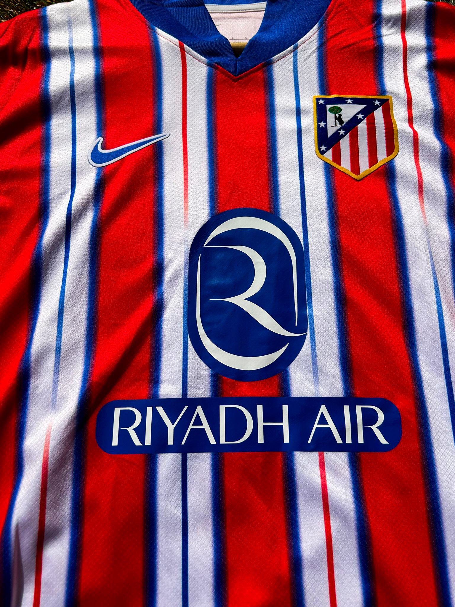Close-up of Nike logo and Atlético Madrid crest on the 2024-2025 home jersey

