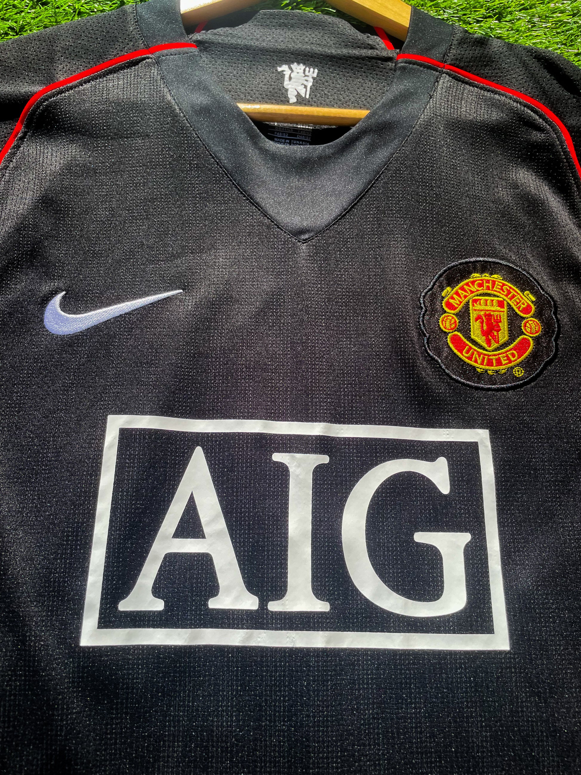 Close-up of gold Nike logo and club crest

