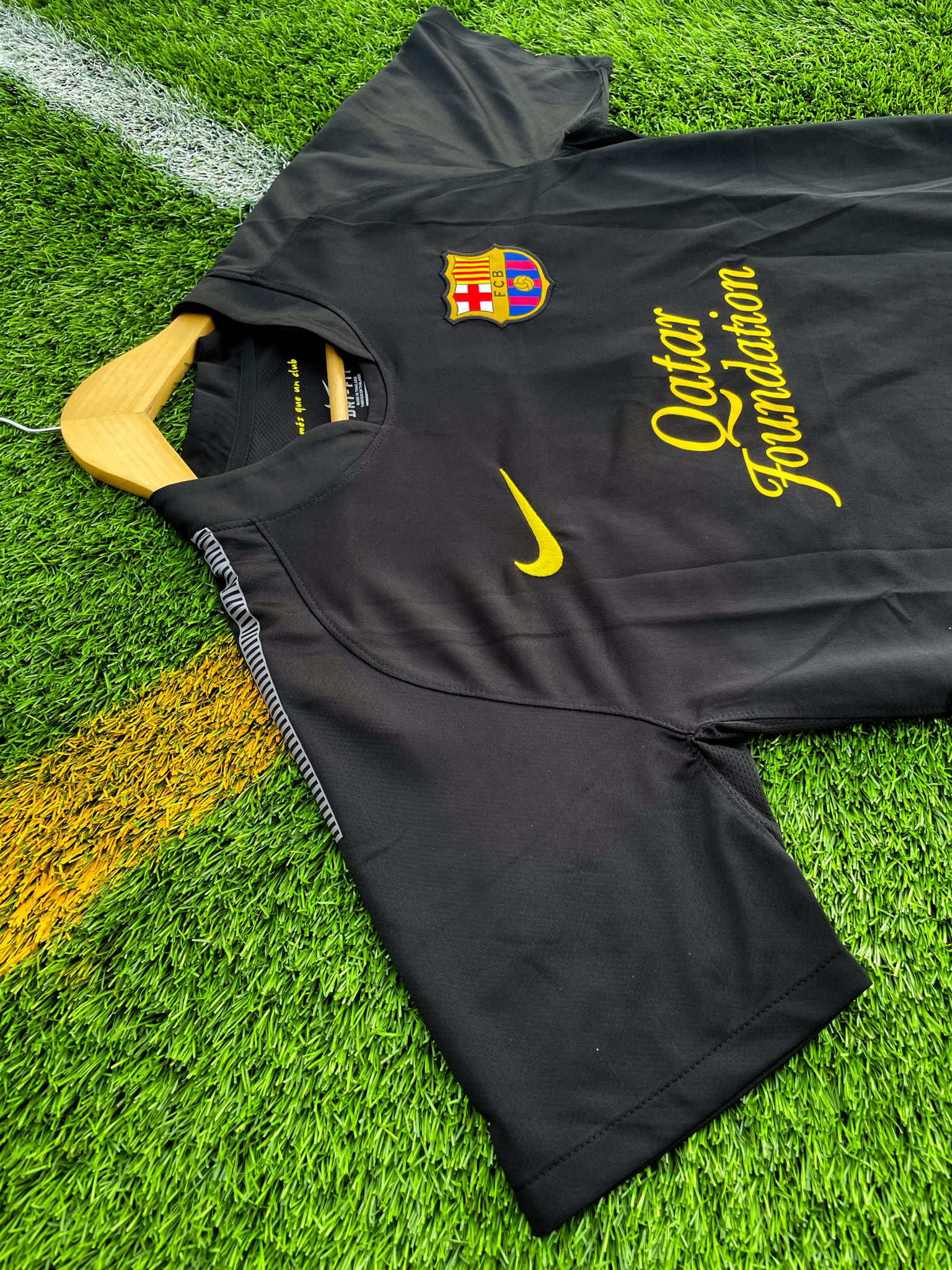Close-up of Barça crest and Nike swoosh on black fabric

