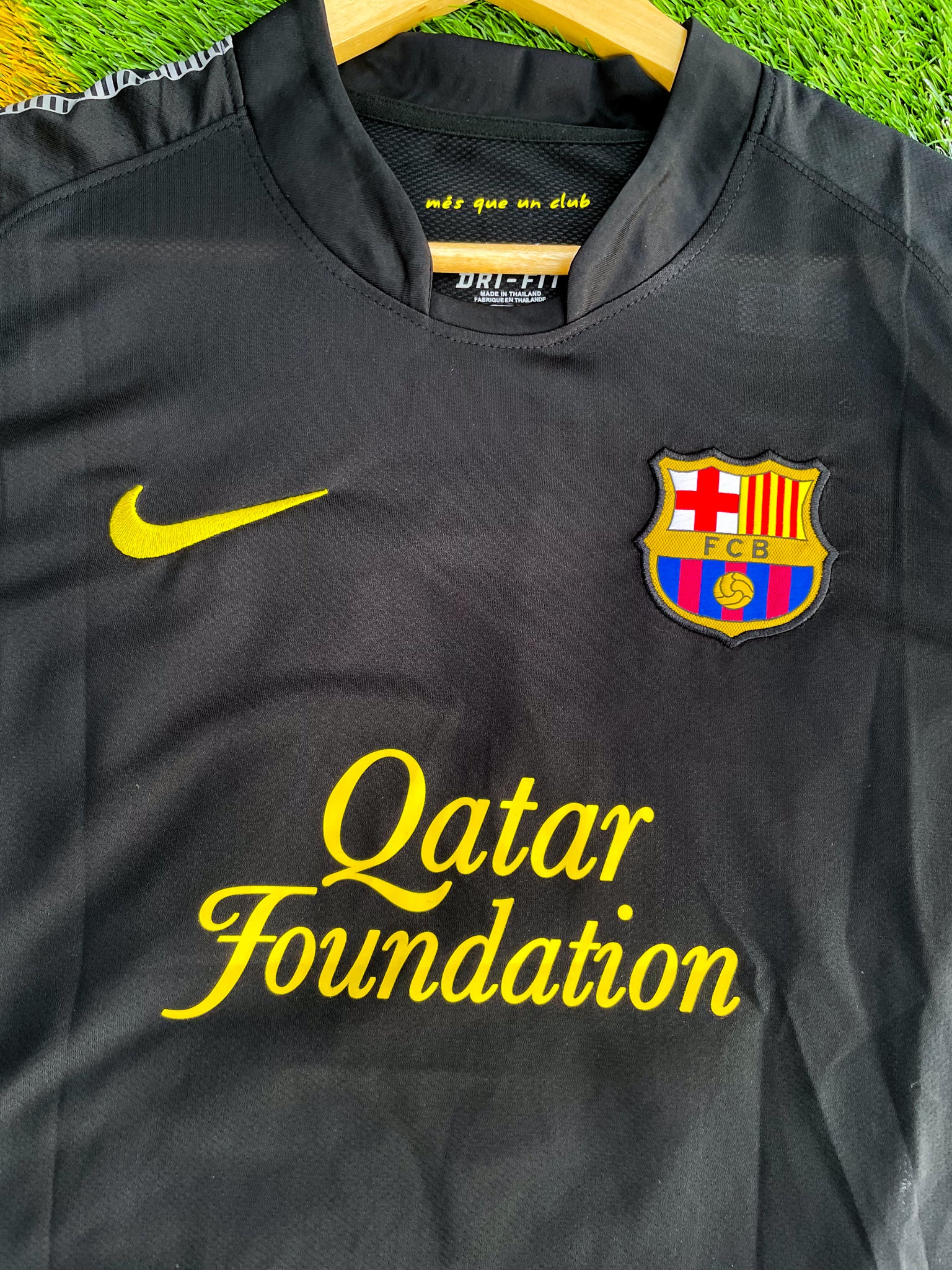 Close-up of Barça crest and Nike swoosh on black fabric

