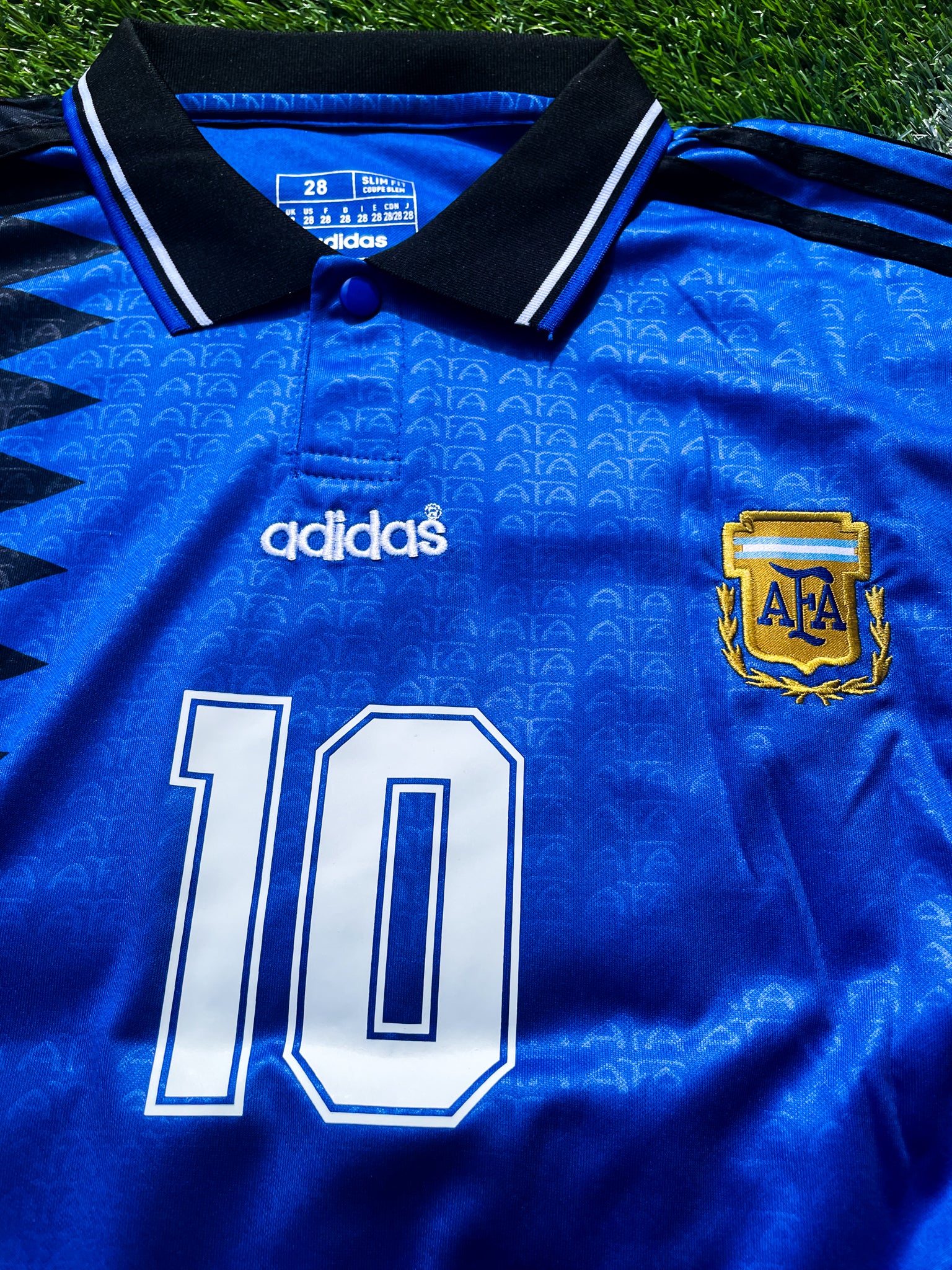 Close-up of the Adidas trefoil and classic collar on the kids’ vintage jersey.