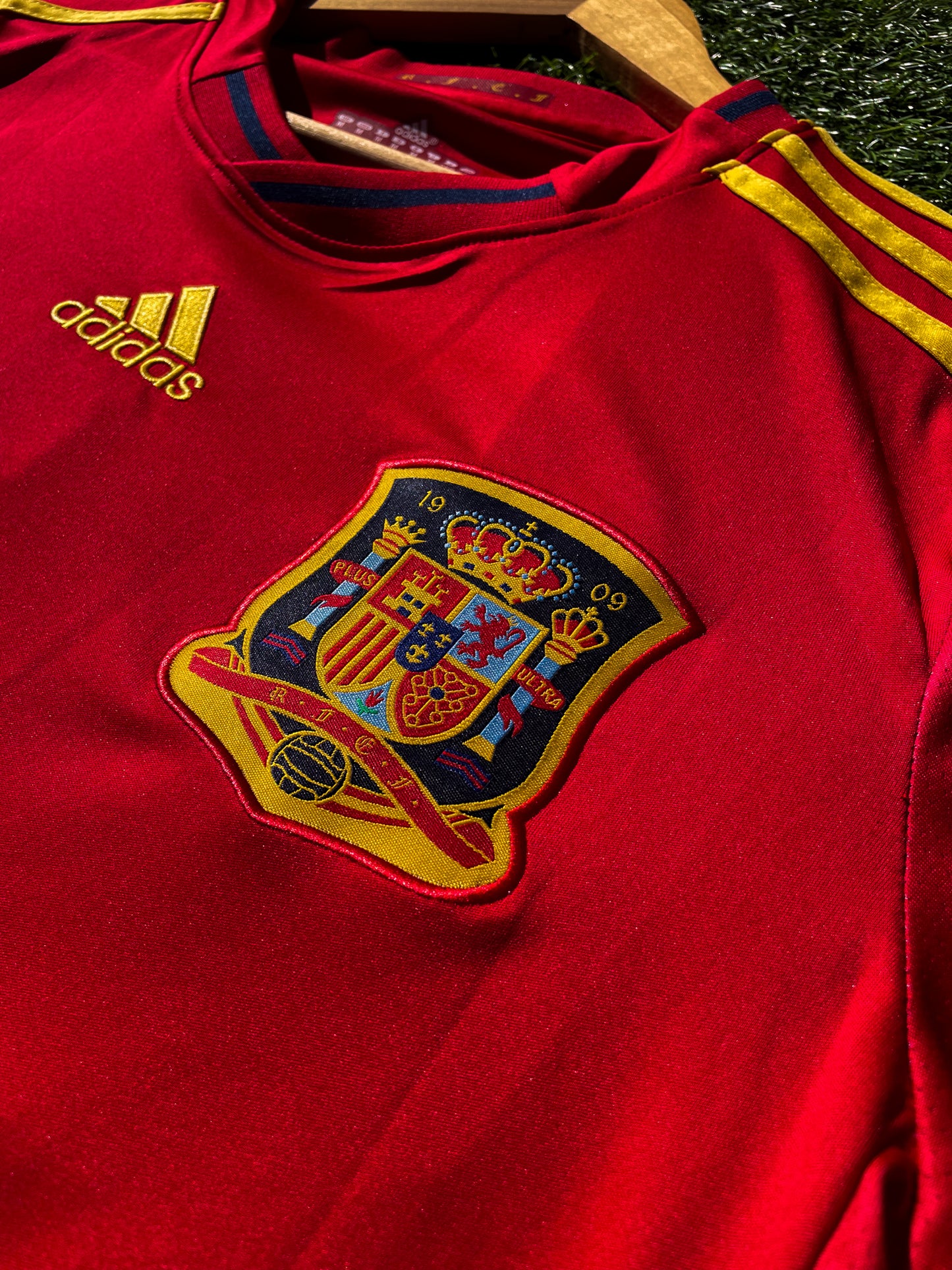Close-up of the RFEF crest and Adidas shoulder logo

