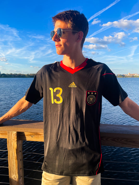 Model wearing Germany 2010 away jersey styled with retro football streetwear

