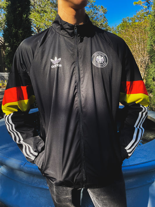 Model wearing the Germany 2024 windbreaker styled with black track pants and retro sneakers