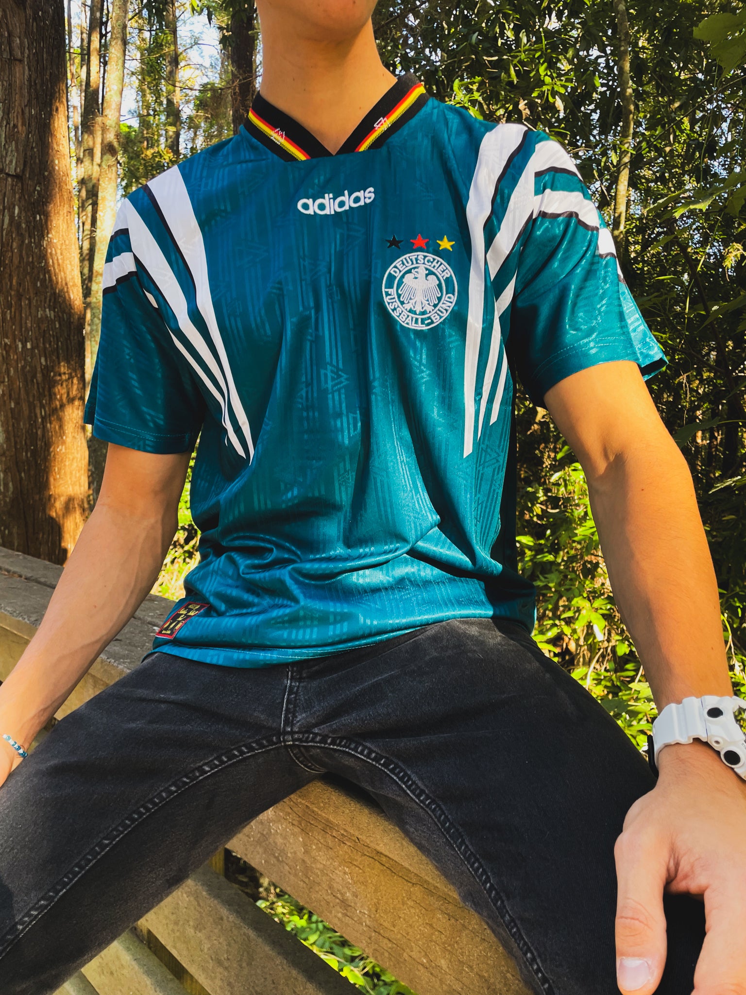 Model styling the Germany 1996 away jersey with retro football casualwear

