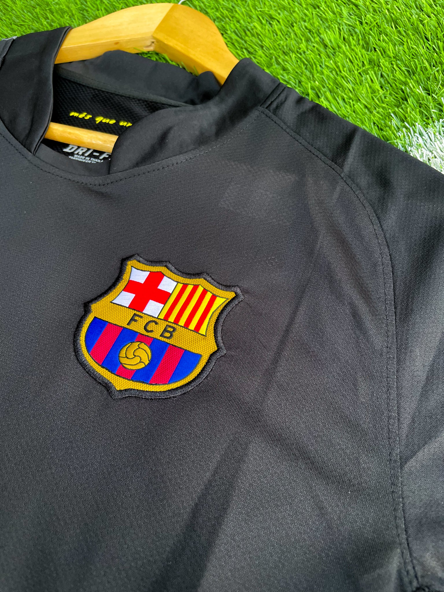 Close-up of Barça crest and Nike swoosh on black fabric

