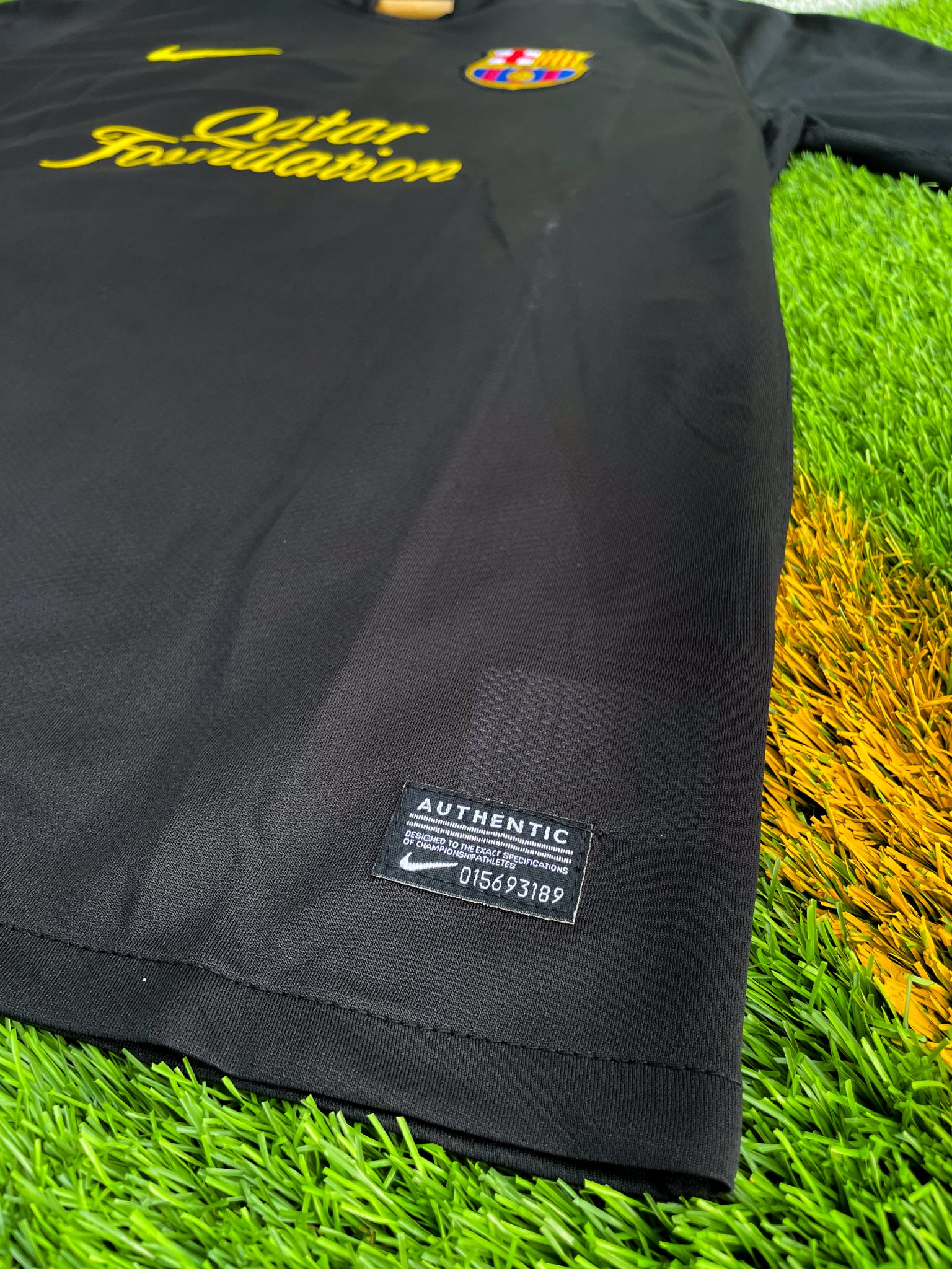 Close-up of Barça crest and Nike swoosh on black fabric

