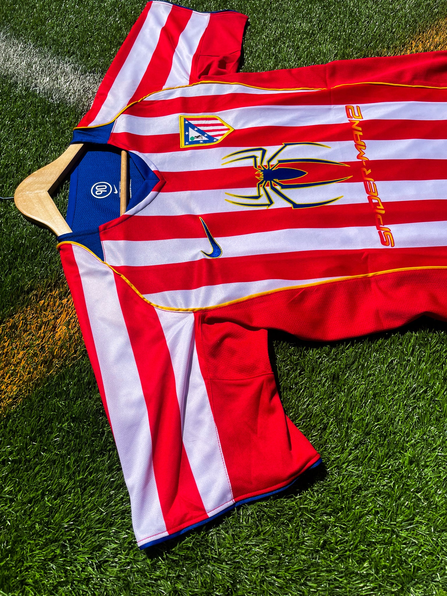 Close-up of Spiderman sponsor logo and embroidered club crest

