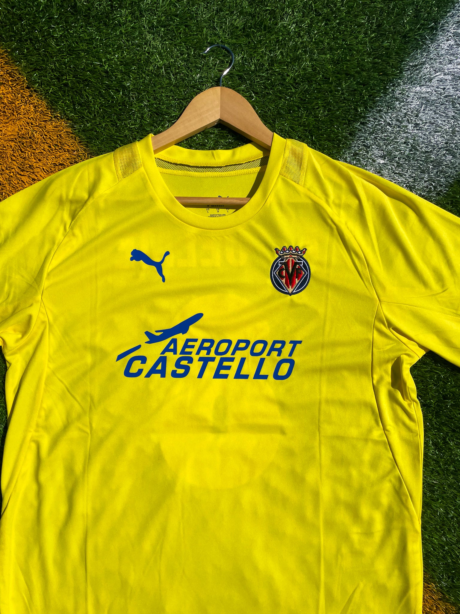 Close-up of embroidered Villarreal crest and sponsor logo

