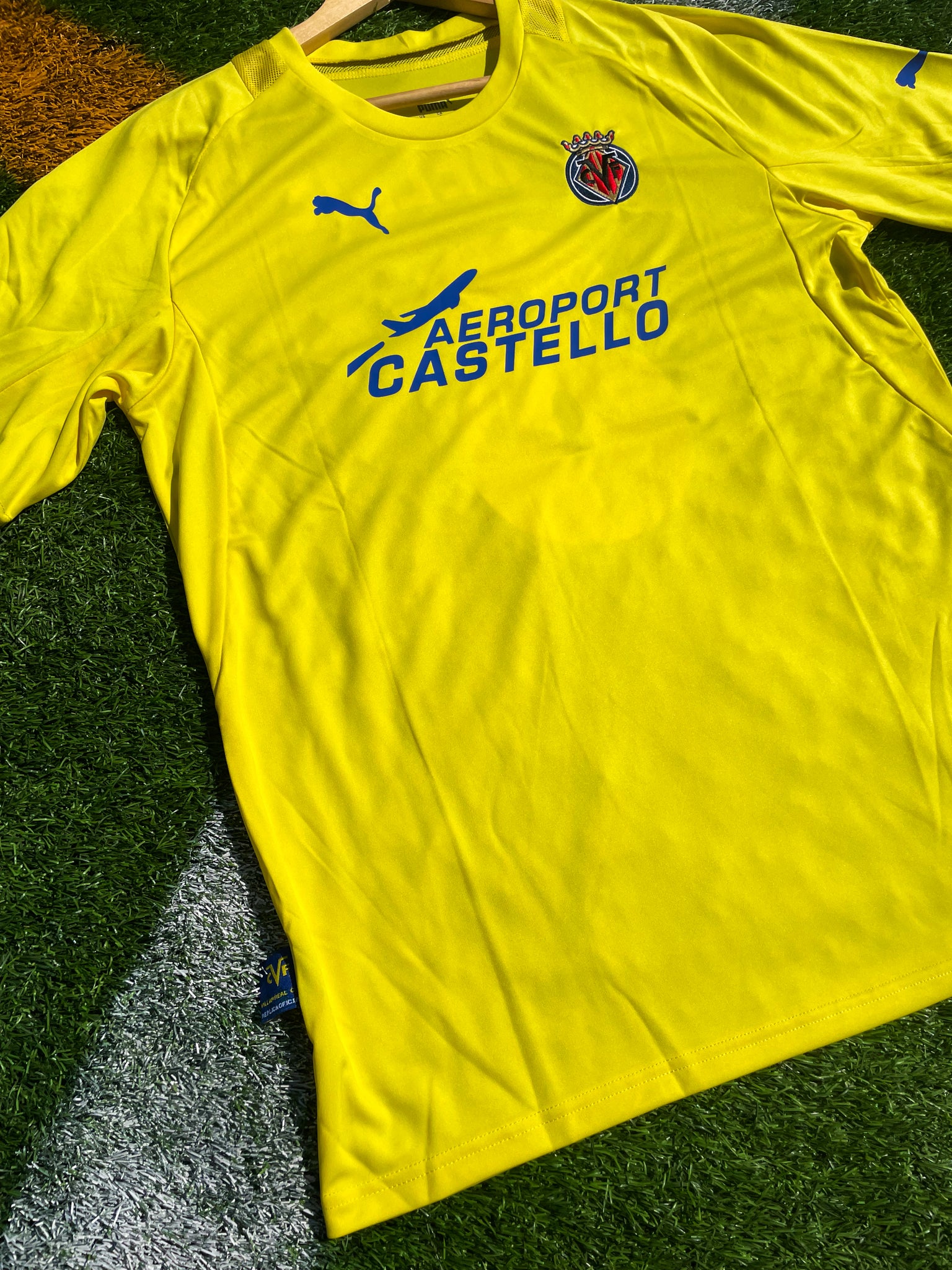 Close-up of embroidered Villarreal crest and sponsor logo

