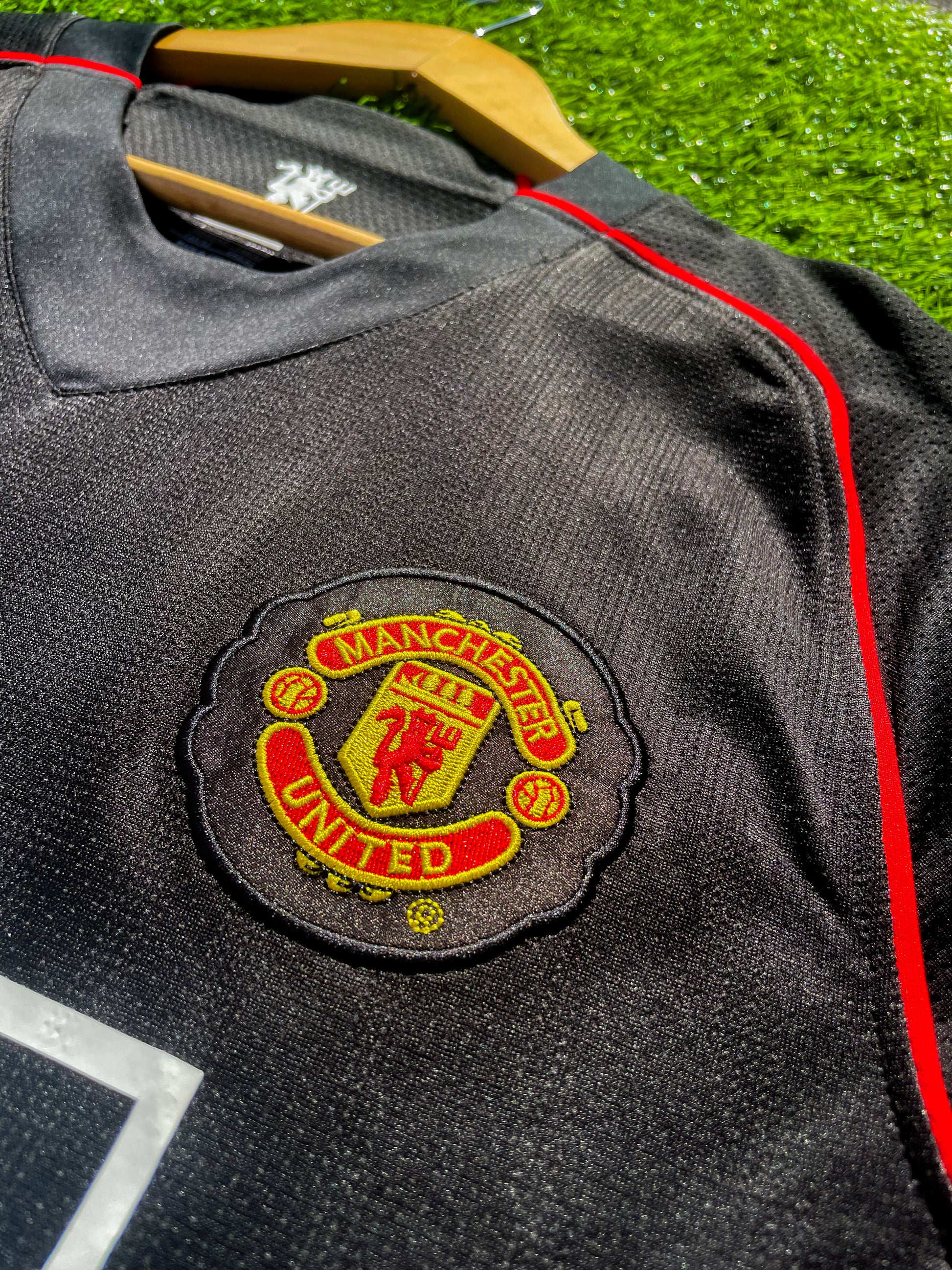 Close-up of gold Nike logo and club crest

