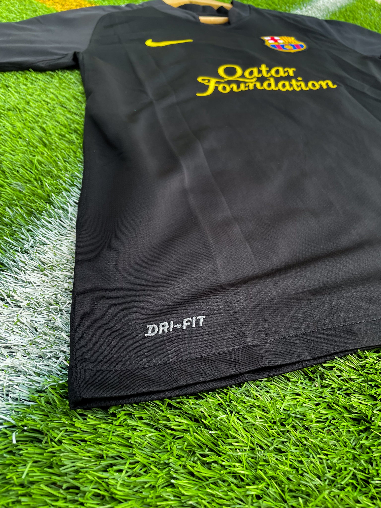 Close-up of Barça crest and Nike swoosh on black fabric

