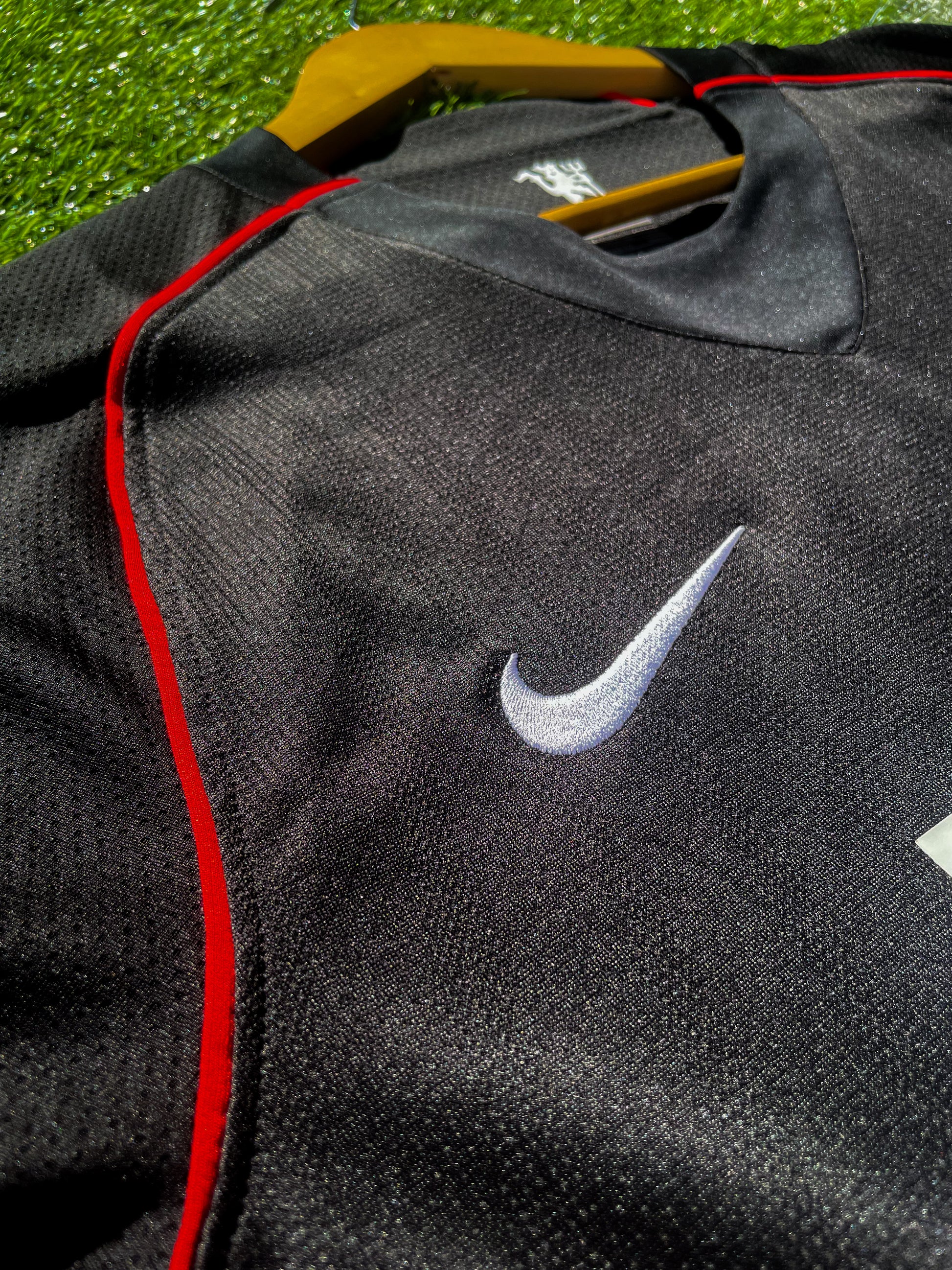 Close-up of gold Nike logo and club crest

