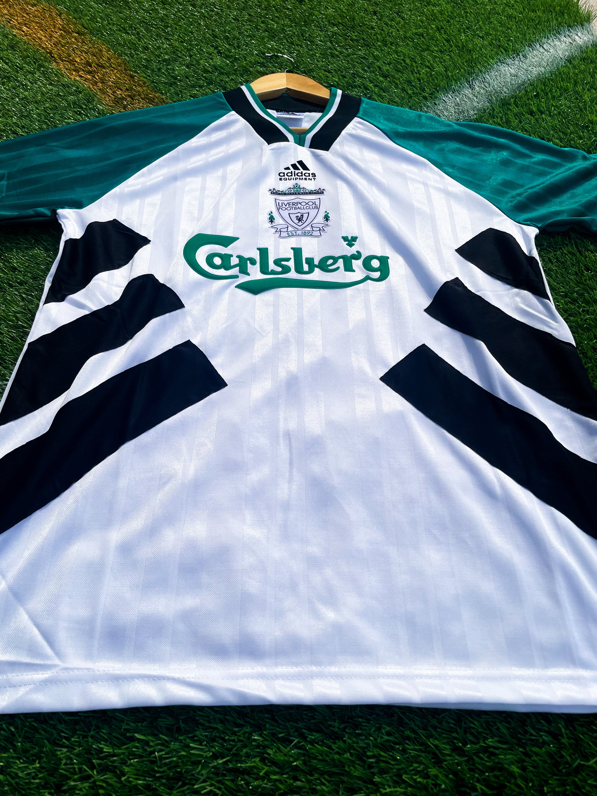 Close-up of retro Adidas logo and green detailing

