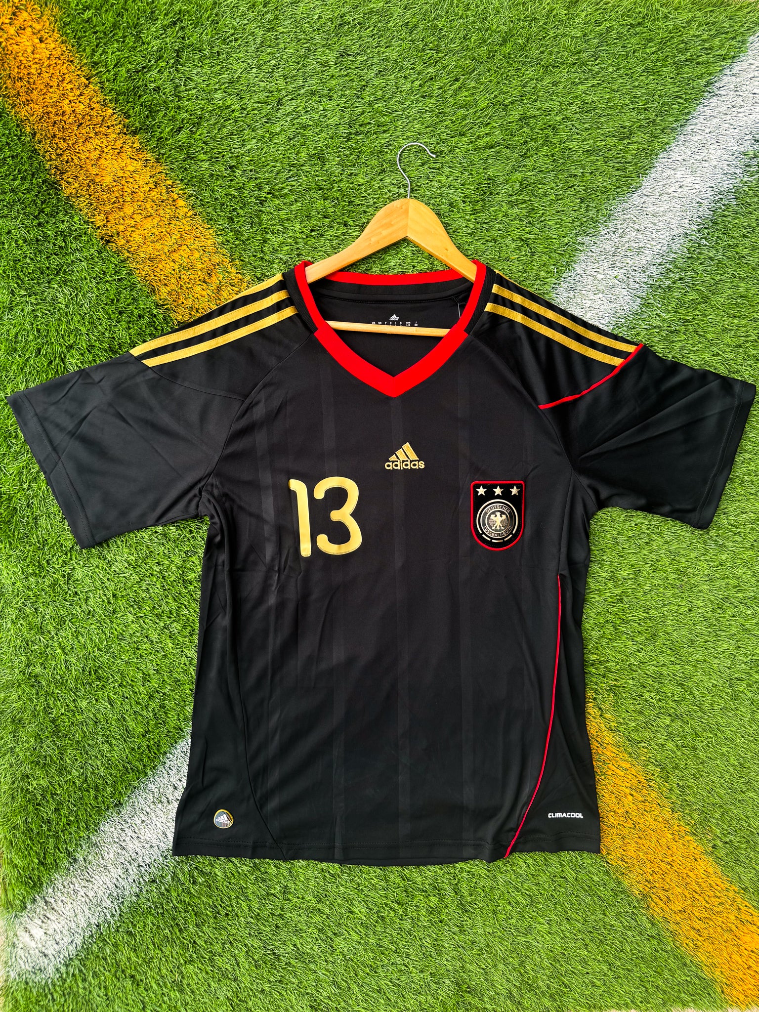 Front view of Germany 2010 away jersey with black base and red/gold details